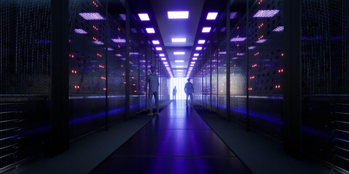 three small human figures in a large data center