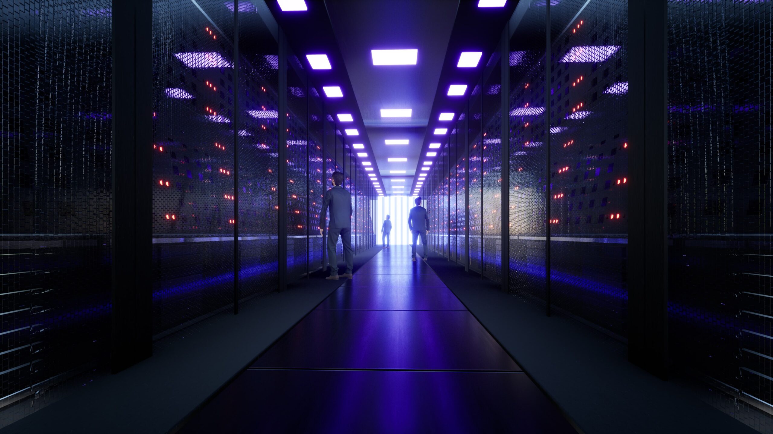 three small human figures in a large data center
